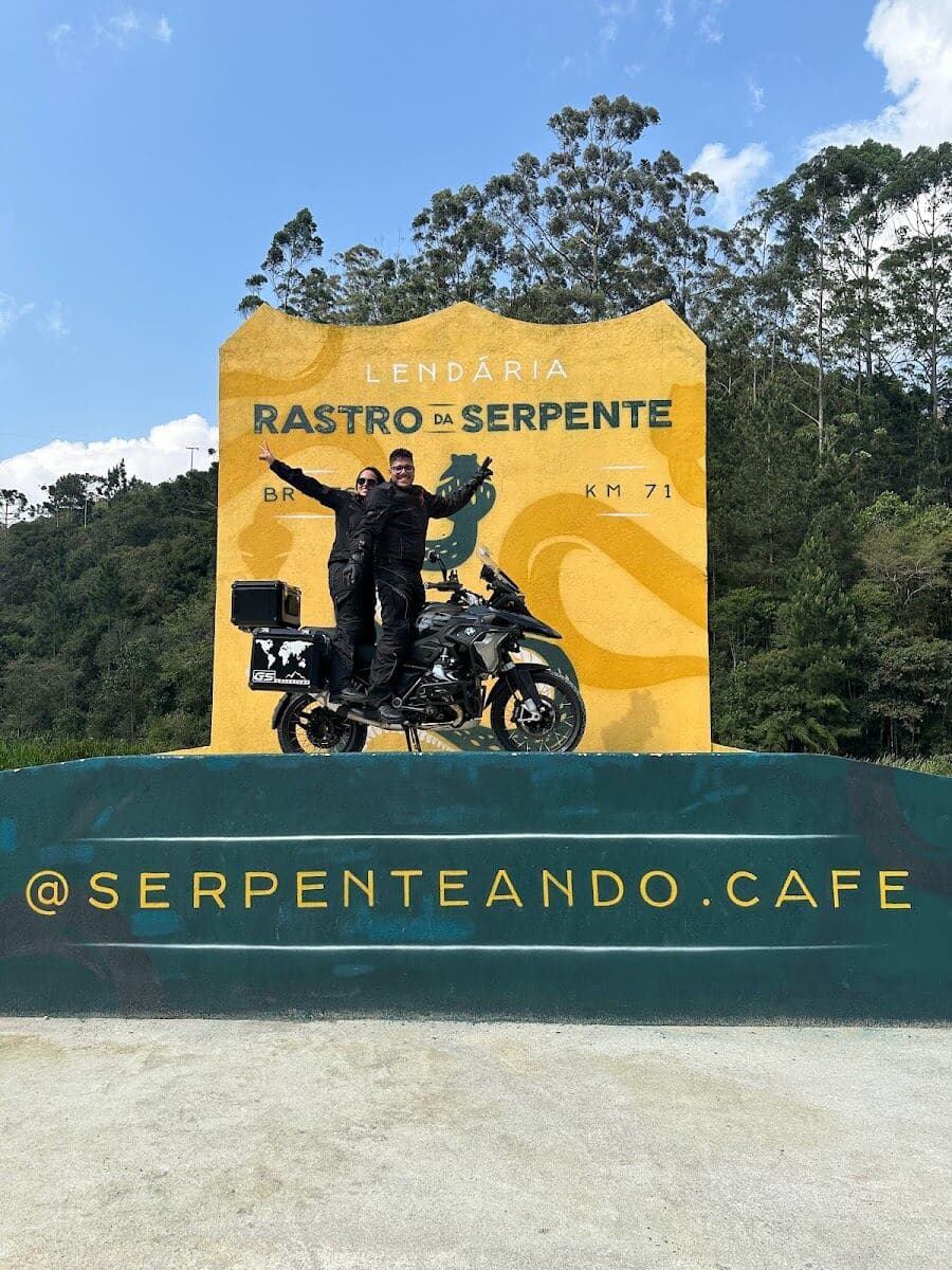 Em pé na moto no letreiro do Rastro da Serpente